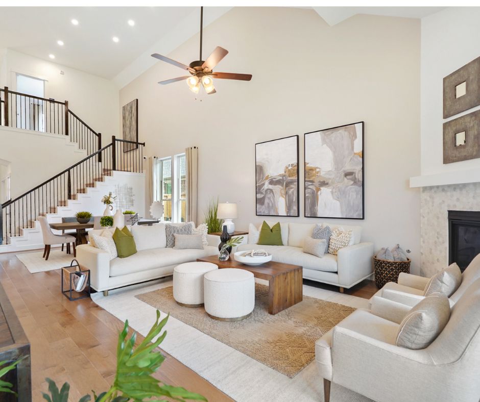 Interior view of foyer inside Pulte model home, with white couch, intimate dining table, and stairs to the second floor visible