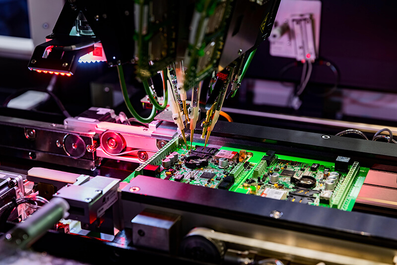 Circuit board being built by a machine in a tech manufacturing plant Circuit board being built by a machine in a tech manufacturing plant