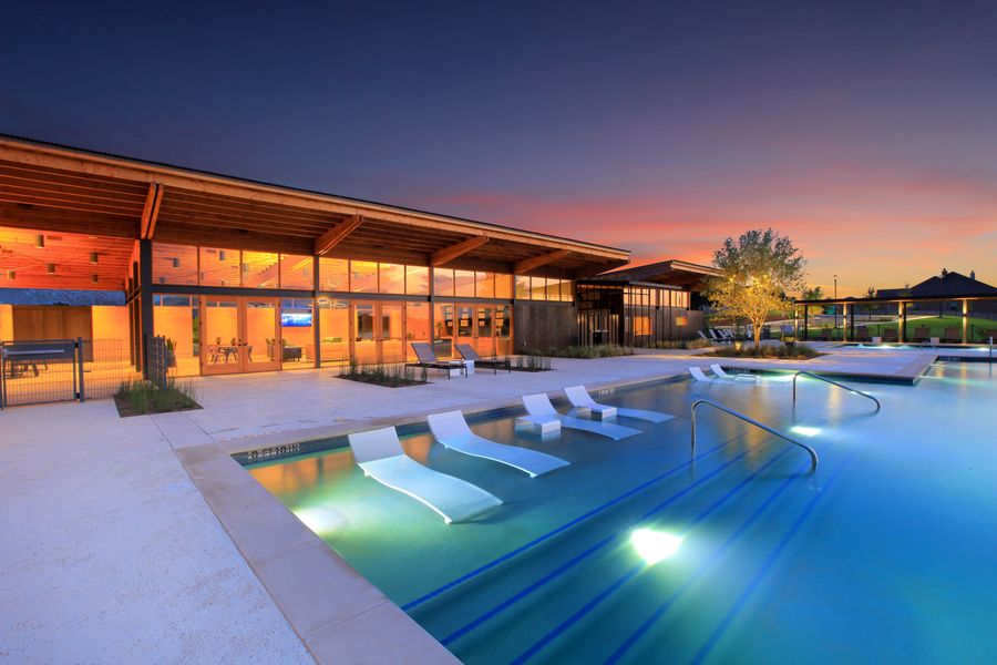 Outdoor pool and deck chairs at dusk at Wolf Ranch's Den amenity Outdoor pool and deck chairs at dusk at Wolf Ranch's Den amenity