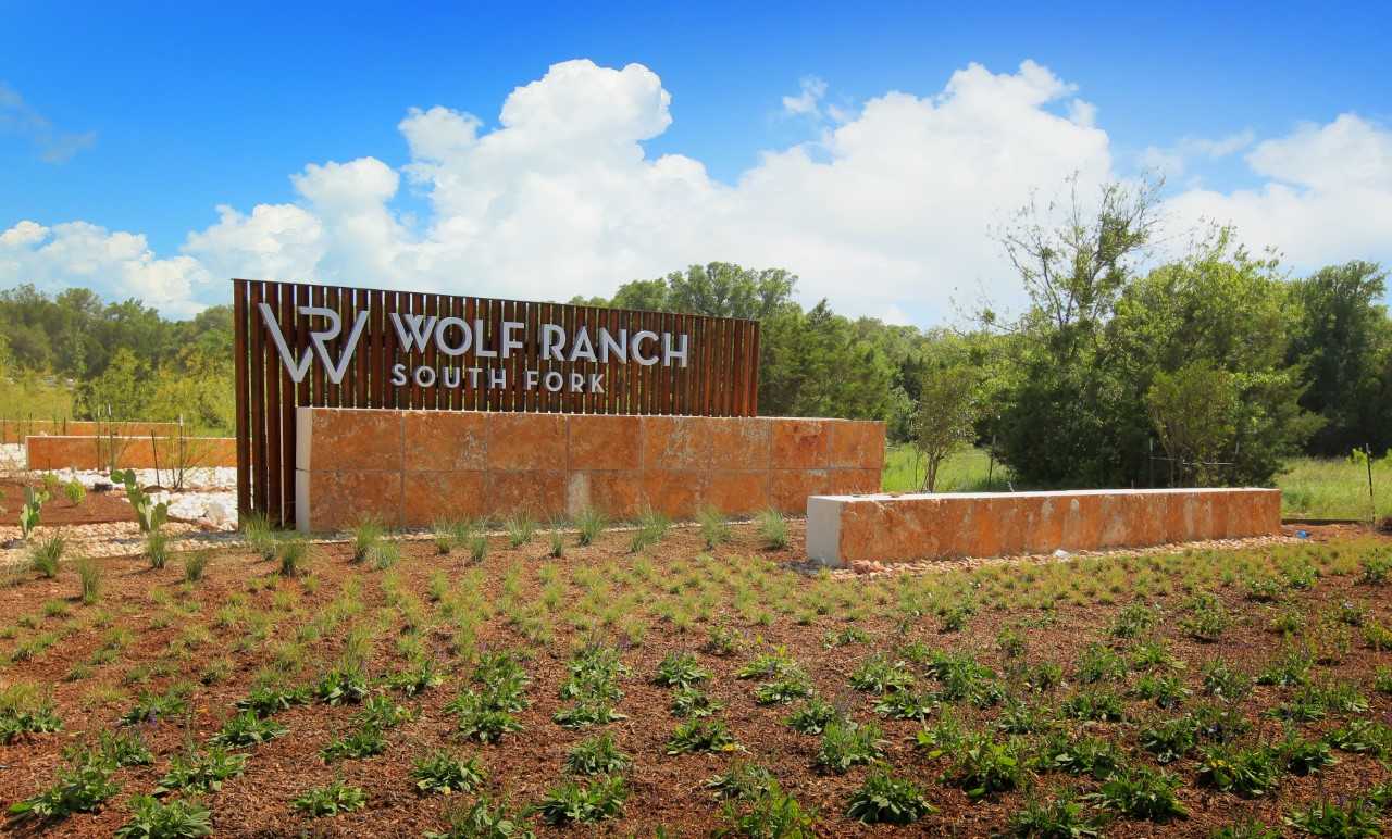 Wolf Ranch community entrance sign against blue sky backdrop Wolf Ranch community entrance sign against blue sky backdrop